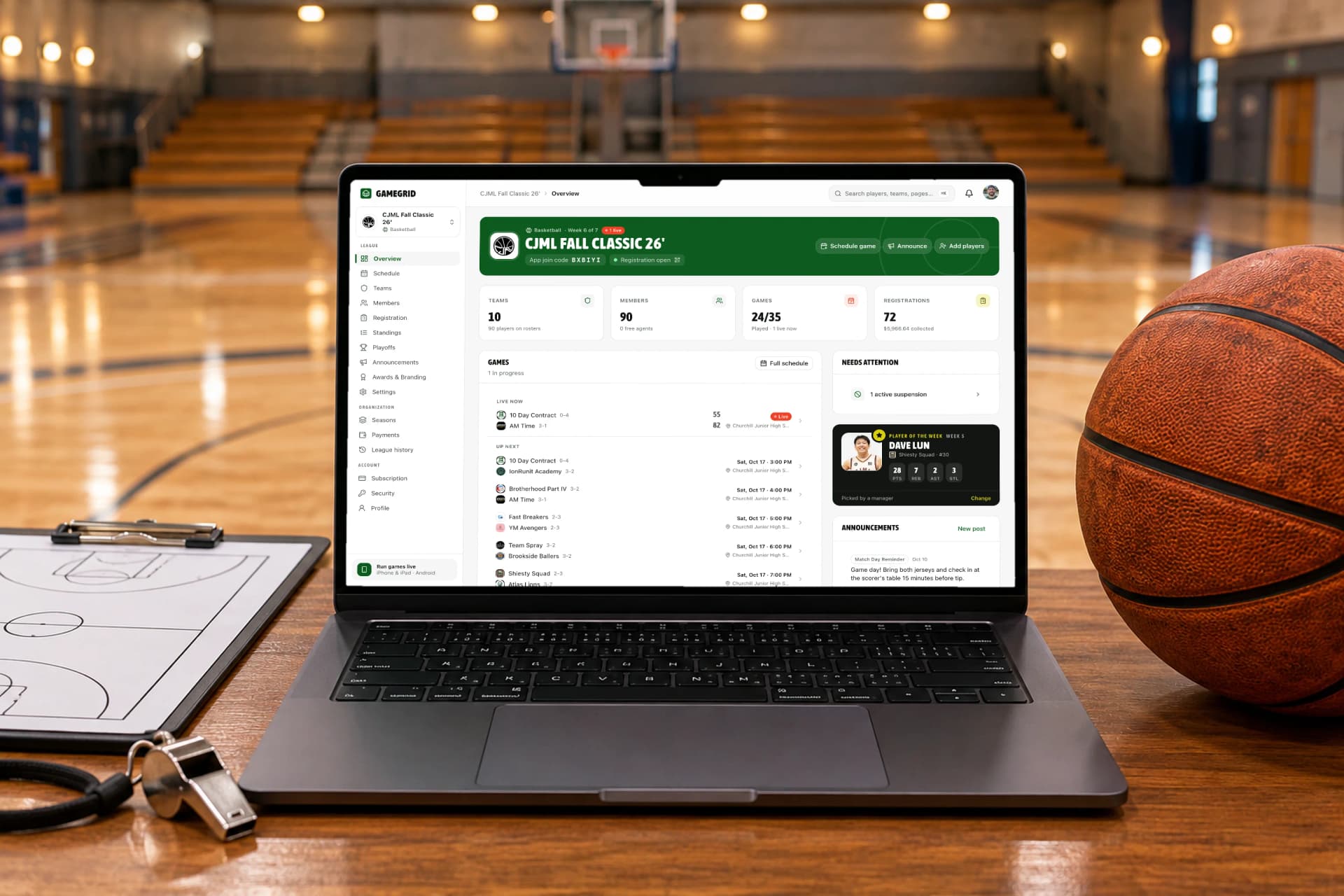 The GameGrid web dashboard on a laptop on a courtside scorer's table: a live game, registrations and the week's schedule